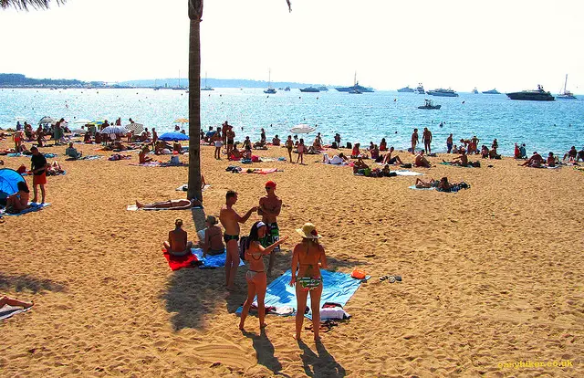 "Full beach in Cannes where a salad nicoise is expensive"