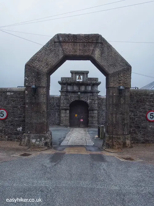 "entrance gate of Dartmoor Prison on a bleak landscape in Dartmoor"