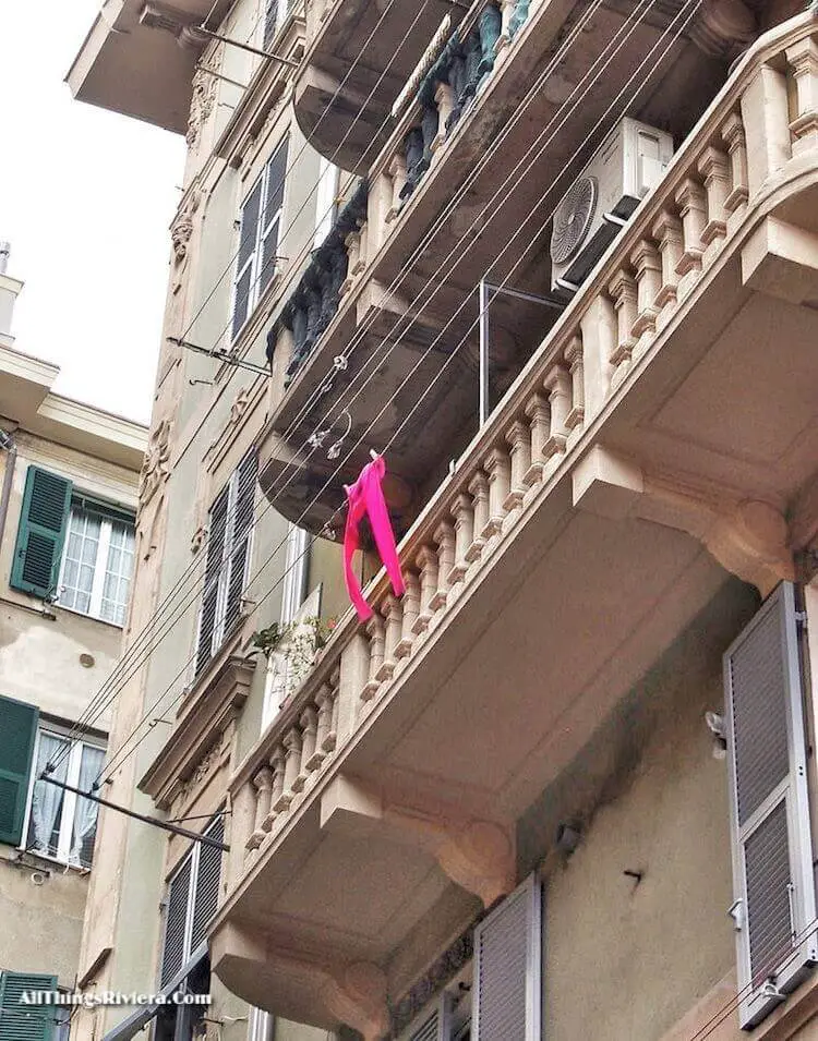 "pink tights hanging on balcony in Sampierdarena"